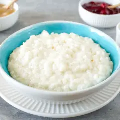 Cremiger Milchreis im blauen Schälchen, bereit für Zimt und Apfelmus. Ein einfaches Milchreis Rezept für gemütliche Momente.