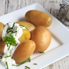 Kleine, goldbraune Kartoffeln mit cremigem Quark und frischem Schnittlauch garniert. Ein einfacher Genuss: Kartoffeln mit Quark.