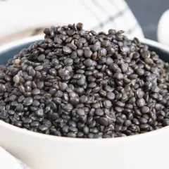 Eine Schüssel voller gekochter Beluga-Linsen, bereit für eine gesunde Mahlzeit.