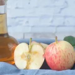 Apfel-Essig-Flasche mit Äpfeln und Blättern. So kannst du ganz einfach Essigmutter herstellen.