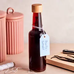 Flasche mit selbstgemachtem Vanilleextrakt, Vanilleschoten und Schnur.