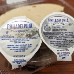 Zwei kleine Becher Philadelphia cream cheese deutsch, original und regular, in einer Plastikverpackung.