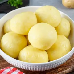 Schüssel mit Klößen, die aus **Stärke aus Kartoffeln** gemacht sind. Sie sind goldgelb und sehen sehr lecker aus.