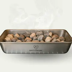 Dampf steigt aus einem Metallbehälter mit Steinen auf. Für knuspriges Brot muss man Wasser in den Ofen geben.