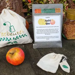 Zutaten für Apfeltee selber machen: Apfel, getrocknete Apfelschale im Glas, Teebeutel-Säckchen.