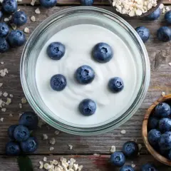 Frischer, veganer Joghurt mit Blaubeeren und Haferflocken – so einfach lässt sich veganen Joghurt selber machen.