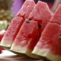 Saftige Wassermelonenstücke mit Kernen, bereit zum Genießen. Das Essen von Wassermelone mit Kernen ist eine gesunde Erfrischung.