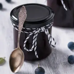 Glas mit Schlehenmarmelade, Löffel und Schlehen. Perfekt für Schlehen Rezepte.