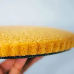 Ein goldbrauner, luftiger veganer Tortenboden wird von einer Hand gehalten. Perfekt für deine nächste Kreation!