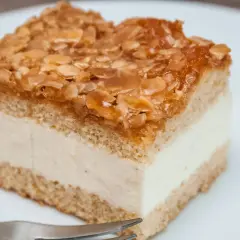 Ein Stück Bienenstich-Kuchen mit cremiger Füllung und karamellisierten Mandeln. Ein leckeres Rezept für den süßen Genuss.