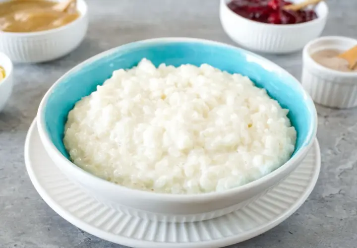 Cremiger Milchreis im blauen Schälchen, bereit für Zimt und Apfelmus. Ein einfaches Milchreis Rezept für gemütliche Momente.