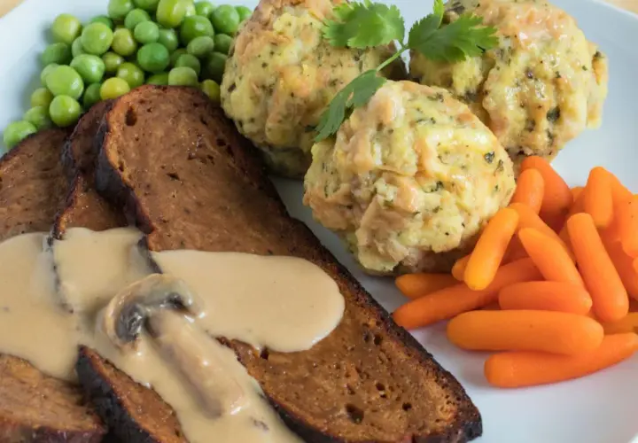 Herzhaftes Gericht mit Scheiben von seitan selber machen, dazu Klöße, Erbsen und Karotten.