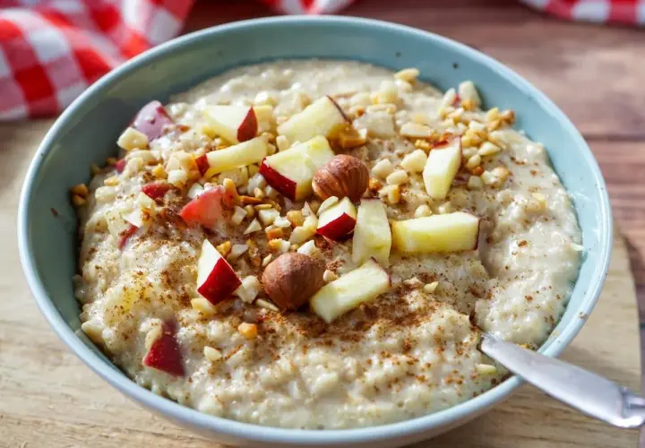 Schüssel mit cremigem Porridge, garniert mit Apfelstücken, Nüssen und Zimt. Perfekt, um Porridge kalt zu essen.