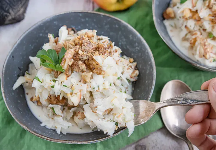 Schwarzer Rettich Zubereitung: Ein cremiger Salat mit Walnüssen und Petersilie, serviert in einer Schüssel.