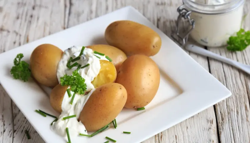 Kleine, goldbraune Kartoffeln mit cremigem Quark und frischem Schnittlauch garniert. Ein einfacher Genuss: Kartoffeln mit Quark.
