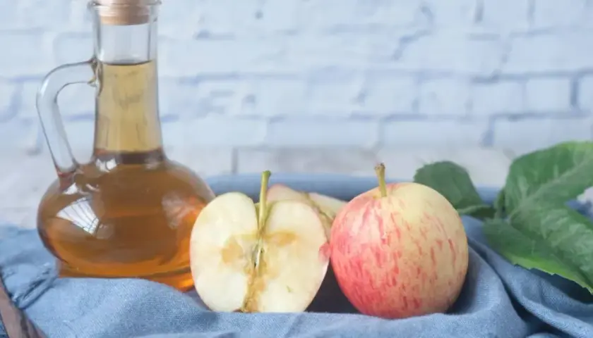 Apfel-Essig-Flasche mit Äpfeln und Blättern. So kannst du ganz einfach Essigmutter herstellen.