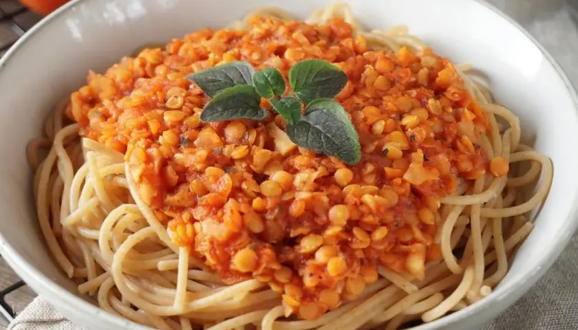 Herzhafte Linsen Bolognese auf Spaghetti, garniert mit frischen Kräutern. Ein köstliches vegetarisches Gericht.