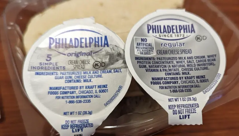 Zwei kleine Becher Philadelphia cream cheese deutsch, original und regular, in einer Plastikverpackung.