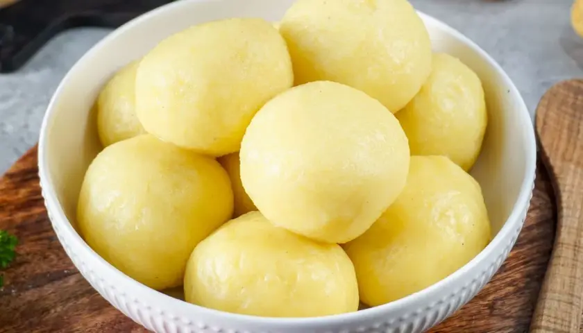 Schüssel mit Klößen, die aus **Stärke aus Kartoffeln** gemacht sind. Sie sind goldgelb und sehen sehr lecker aus.
