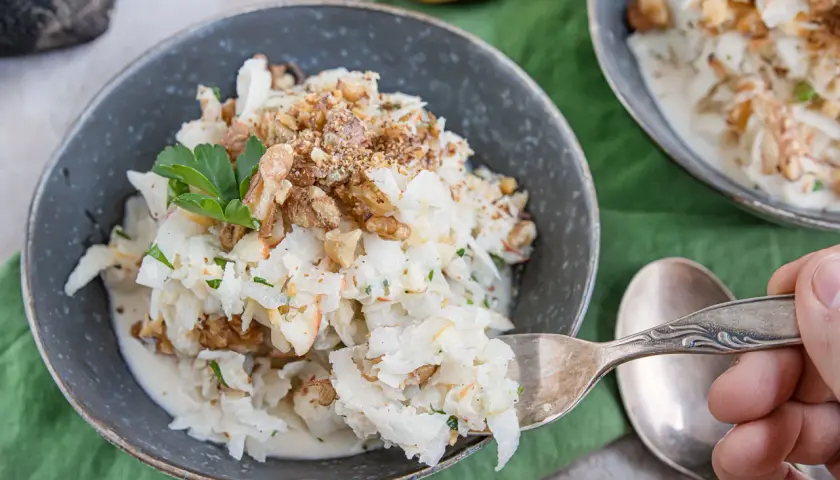 Schwarzer Rettich Zubereitung: Ein cremiger Salat mit Walnüssen und Petersilie, serviert in einer Schüssel.