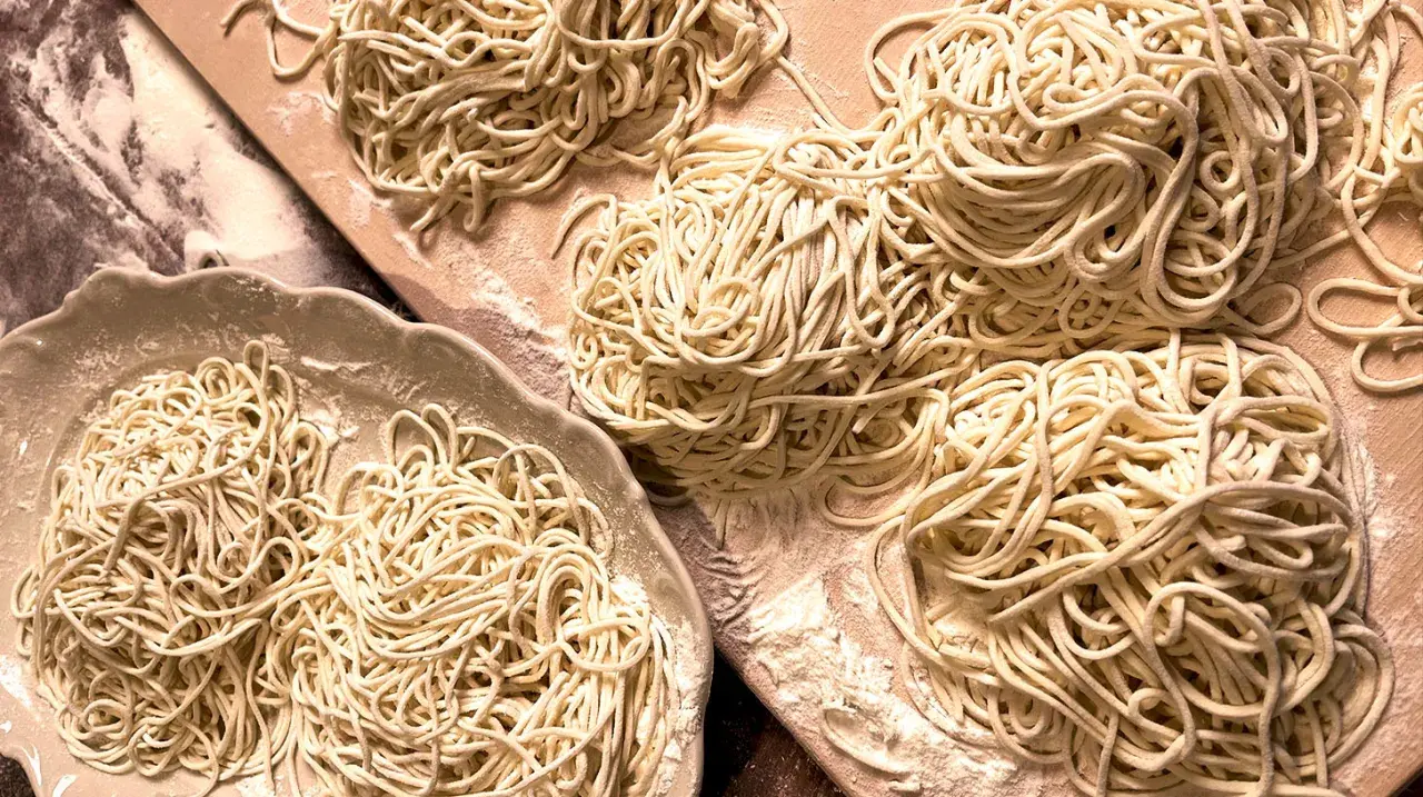 Frisch gemachte, glutenfreie Nudeln liegen auf einer Platte und einem Holzbrett. Perfekt für alle, die glutenfreie Nudeln selber machen wollen.