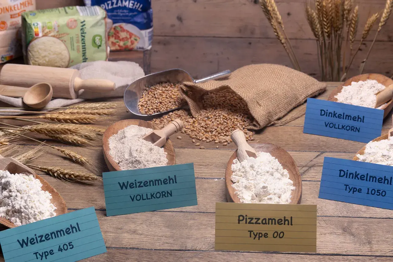 Verschiedene Mehlsorten, darunter Pizzamehl Type 00, Weizenmehl und Dinkelmehl. Die Frage, ob man mit Pizzamehl Kuchen backen kann, wird hier thematisiert.