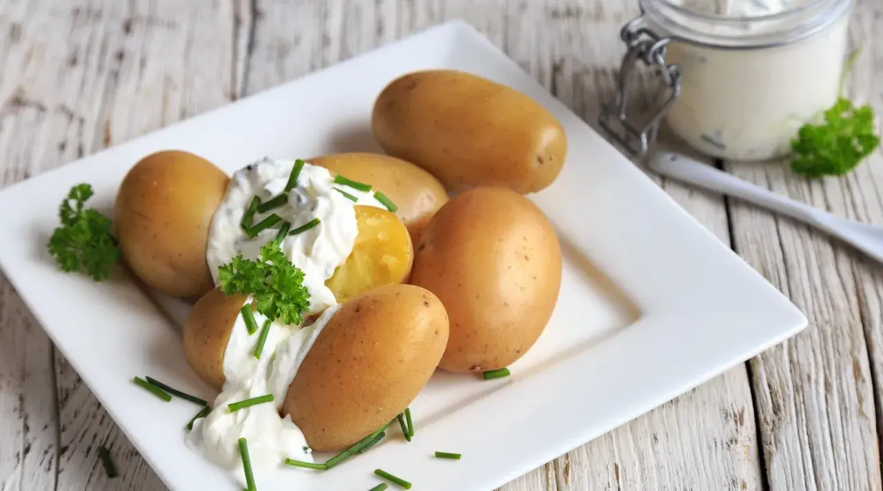 Kleine, goldbraune Kartoffeln mit cremigem Quark und frischem Schnittlauch garniert. Ein einfacher Genuss: Kartoffeln mit Quark.