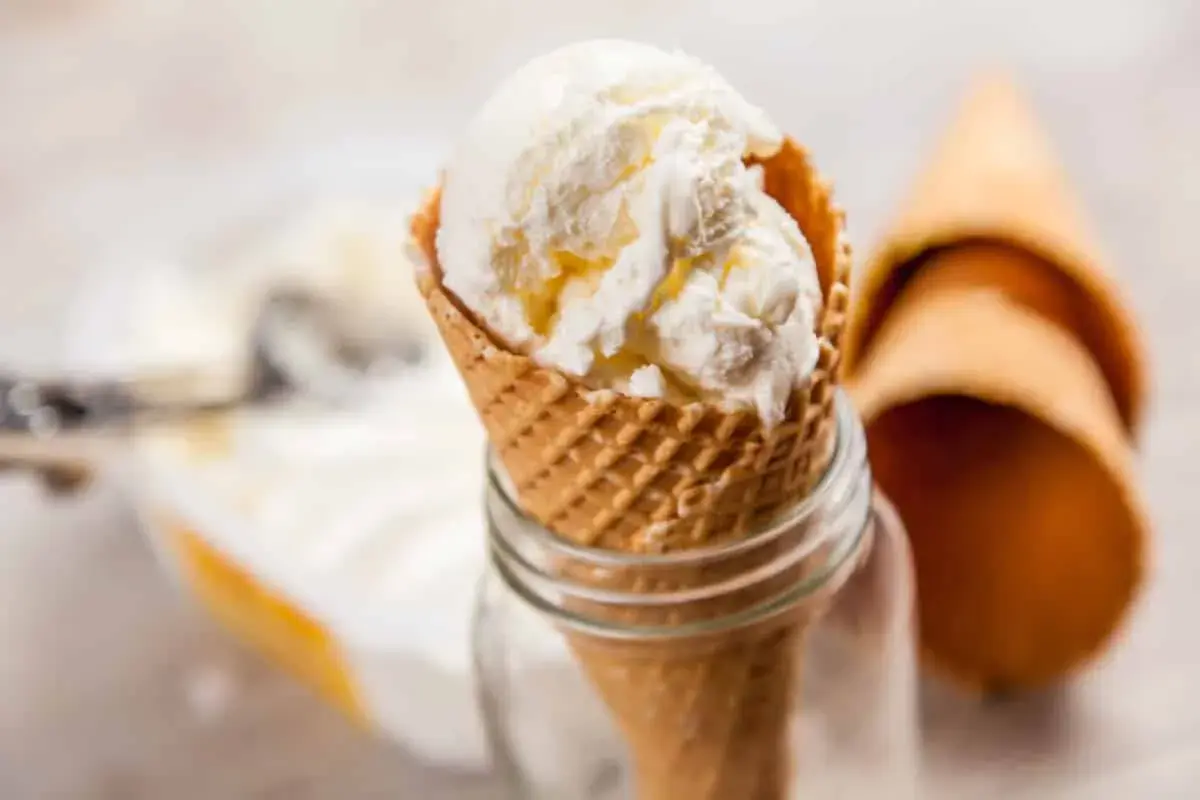 Cremiges griechischer joghurt eis ohne eismaschine im Waffelhörnchen, daneben leere Hörnchen.