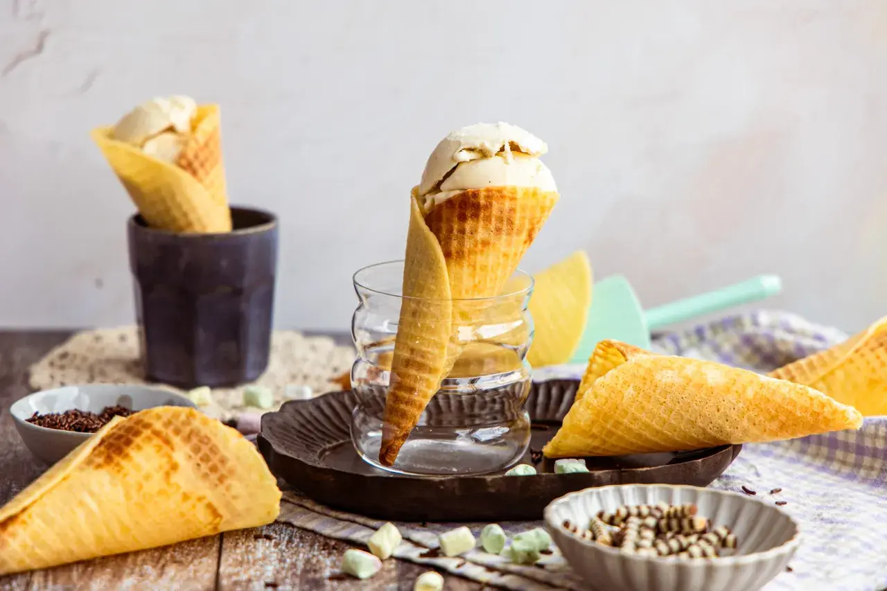Eiswaffeln selber machen: goldbraune Waffeln mit Vanilleeis, Schokostreuseln und bunten Marshmallows.