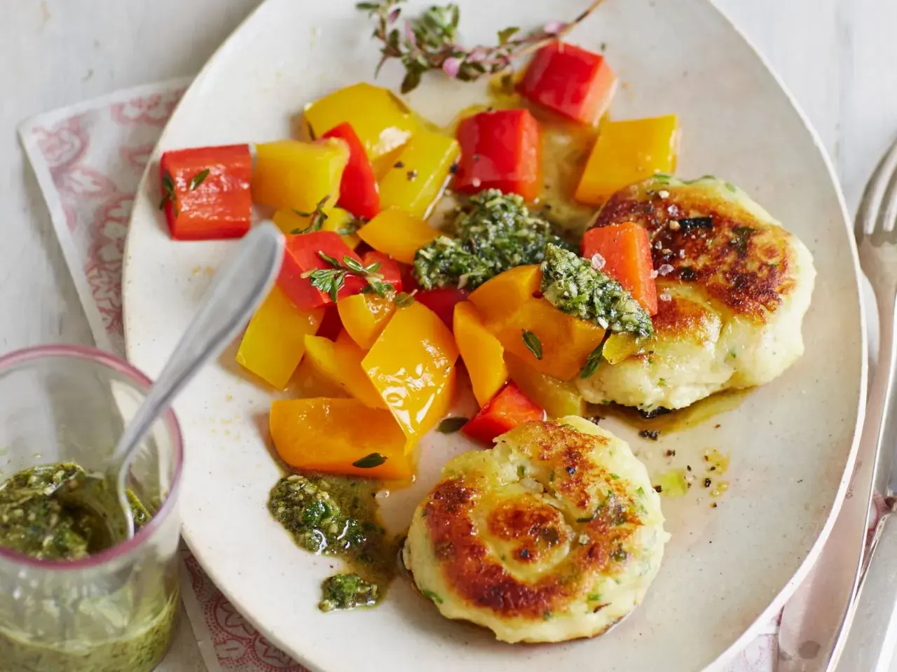 Zarte kartoffelküchlein aus gekochten Kartoffeln, serviert mit bunter Paprika und Kräuterpesto.