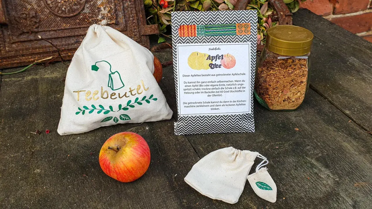 Zutaten für Apfeltee selber machen: Apfel, getrocknete Apfelschale im Glas, Teebeutel-Säckchen.