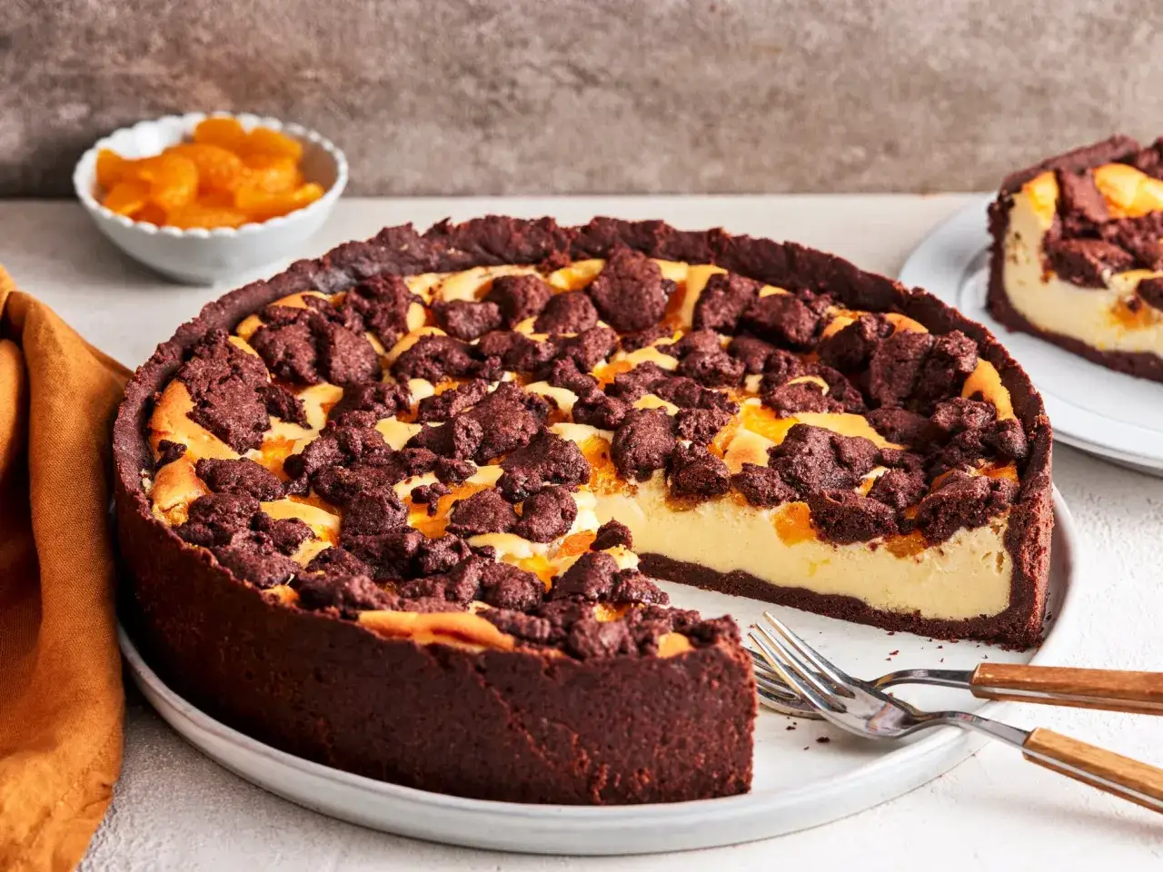 Ein saftiger russischer Zupfkuchen mit Schokoladenboden, cremiger F&uuml;llung und Mandarinenst&uuml;cken, bestreut mit dunklen Schokoladenkr&uuml;meln.