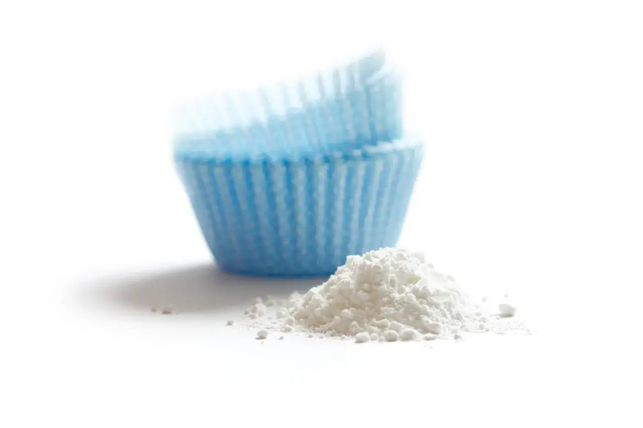 Ein Haufen wei&szlig;es Pulver, vielleicht Natron, liegt neben blauen Muffinf&ouml;rmchen.
