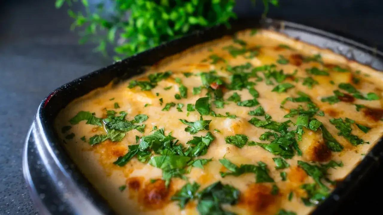Cremiges Kartoffelgratin, frisch aus dem Ofen, mit Petersilie bestreut. Ein k&ouml;stliches Rezept f&uuml;r jeden Anlass.