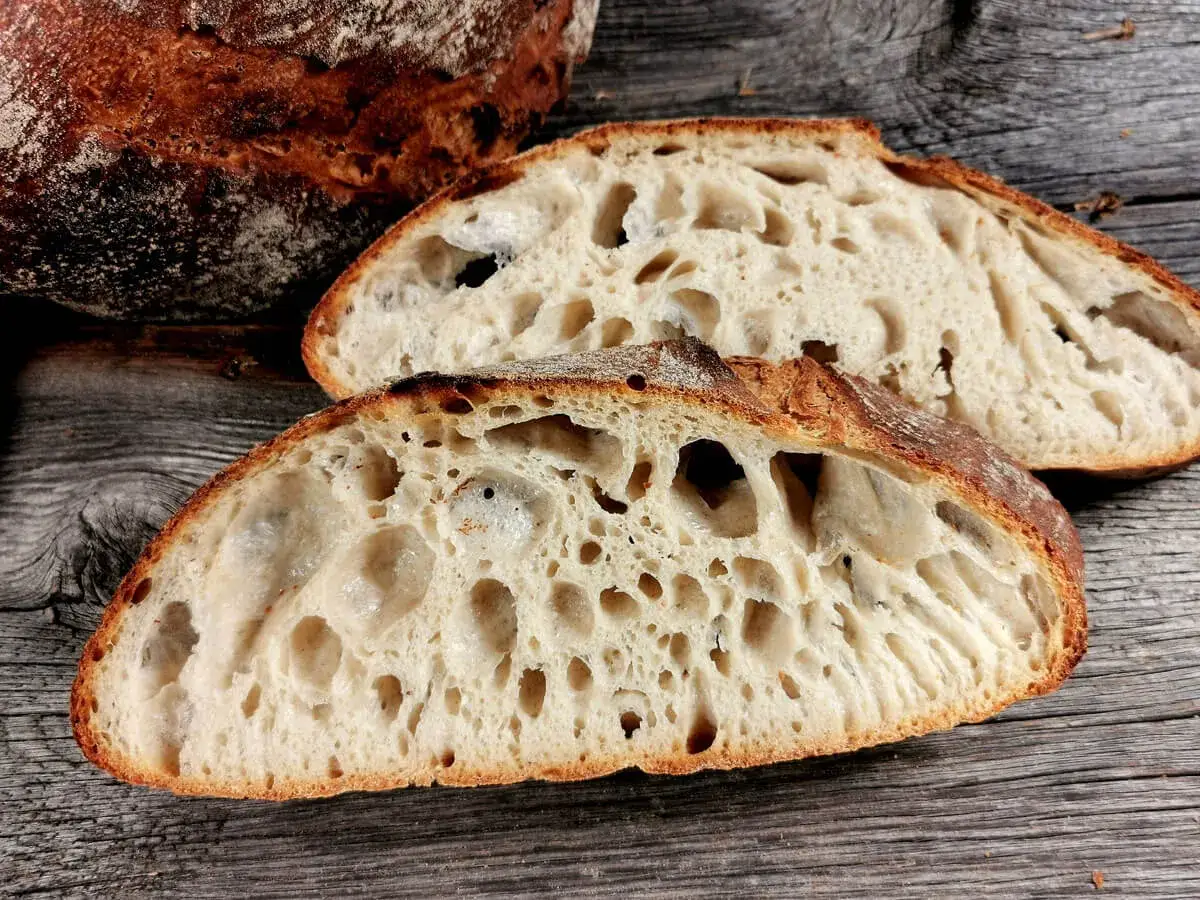 Sauerteigbrot mit gro&szlig;er Krume und deutlichen Luftl&ouml;chern. Das Brot geht beim Backen nicht auf, was zu dieser dichten Struktur f&uuml;hrt.