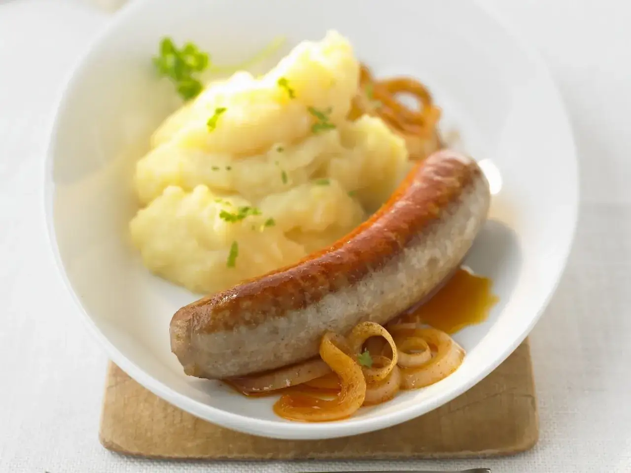 Herzhafte Bratwurst mit cremigem Kartoffelp&uuml;ree und karamellisierten Zwiebeln. Ein Klassiker f&uuml;r alle Bratwurst Rezepte Liebhaber.