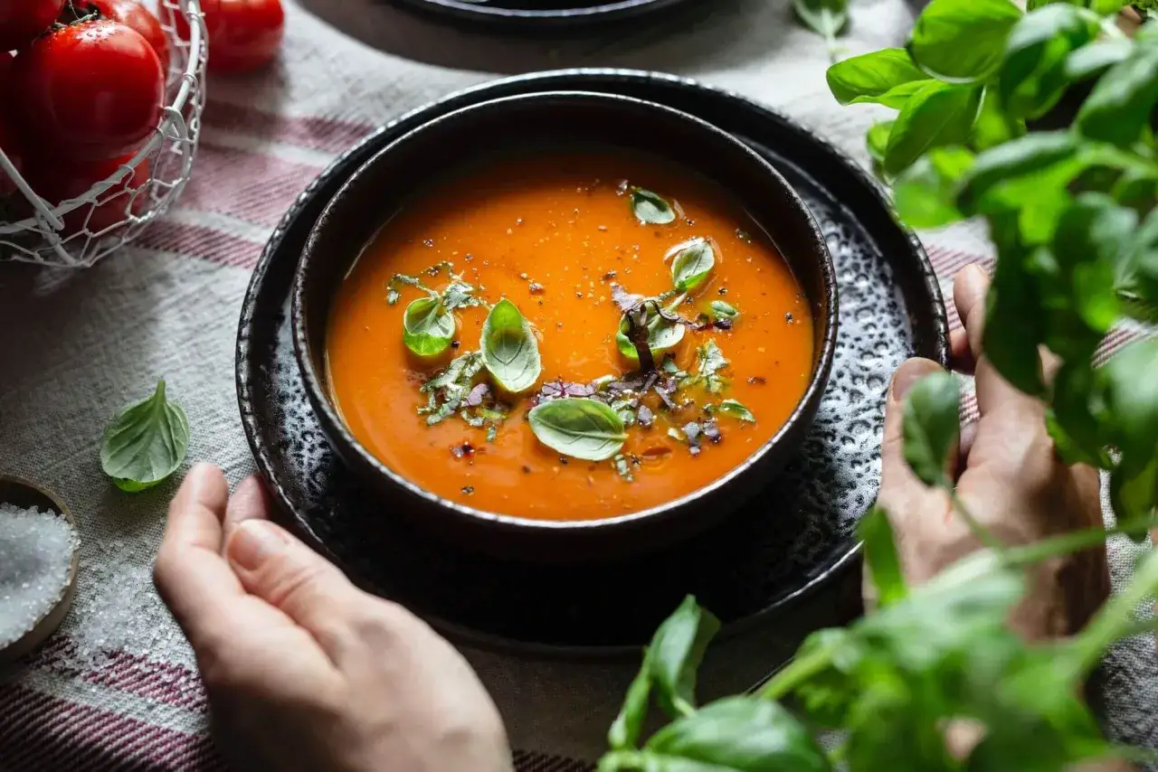 Eine Sch&uuml;ssel mit leckerer Tomatensuppe, garniert mit Basilikum. Perfekt f&uuml;r ein Tomatensuppe Rezept mit frischen Tomaten.