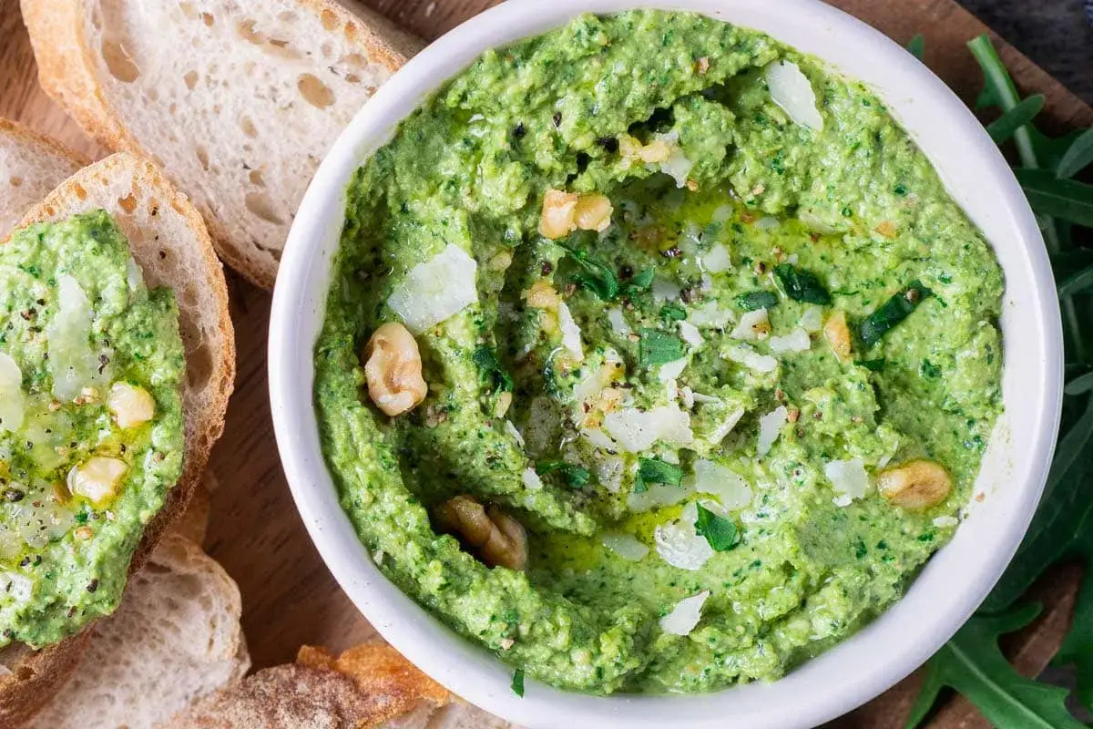 Frisches Rucola Pesto mit N&uuml;ssen und Parmesan, serviert mit knusprigem Brot. Ein Genuss f&uuml;r jeden Gaumen!