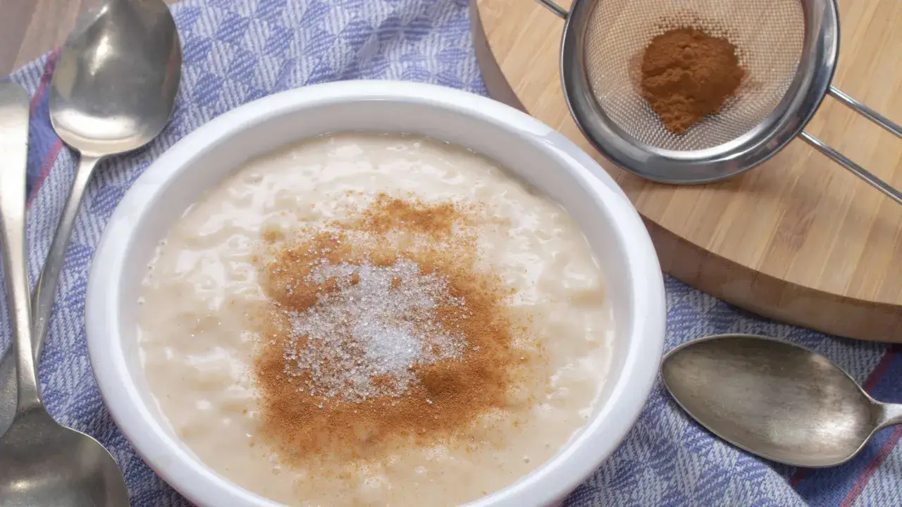 Cremiger Milchreis, bestreut mit Zucker und Zimt, bereit zum Genie&szlig;en. Ein einfaches und leckeres Milchreis Rezept.