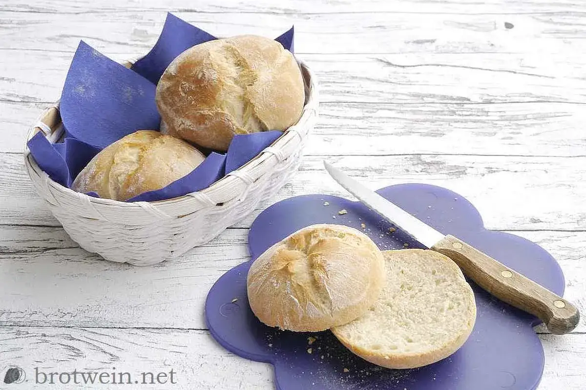 Frisch gebackenes Brot, Br&ouml;tchen in einem Korb und auf einem Schneidebrett, bereit zum Genuss.