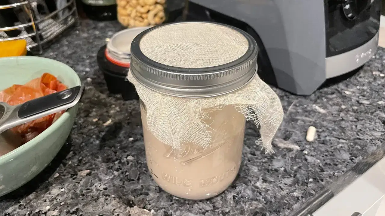 Glas mit Gaze abgedeckt, bereit, vegane Butter selber zu machen. Daneben eine Sch&uuml;ssel mit Zutaten.