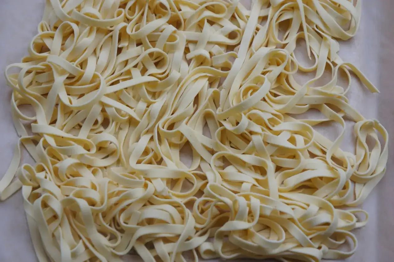 Frische, selbstgemachte glutenfreie Nudeln liegen auf einem Backpapier. Perfekt f&uuml;r alle, die glutenfreie Nudeln selber machen m&ouml;chten.
