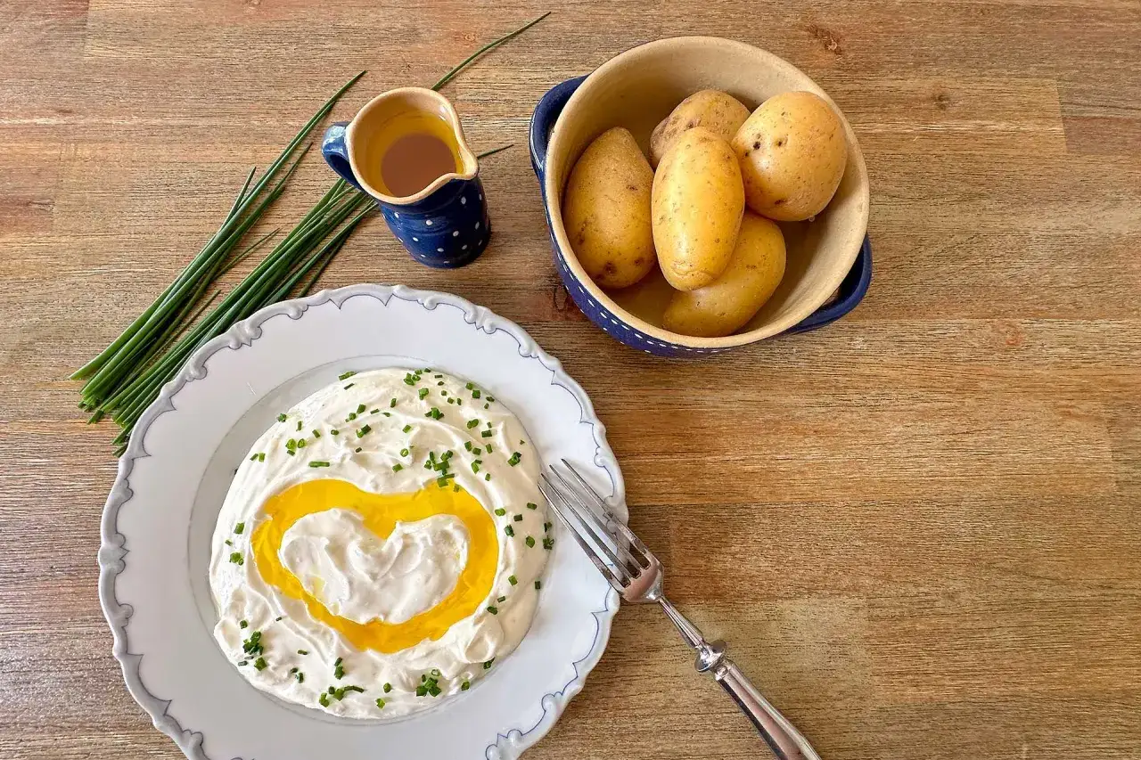 Herzf&ouml;rmiger Quark mit Schnittlauch, dazu Pellkartoffeln und ein kleines K&auml;nnchen mit &Ouml;l. Ein liebevolles Gericht f&uuml;r Kartoffeln mit Quark.